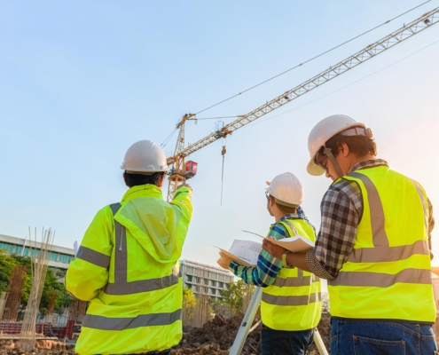 Back view of a group of construction workers analyzing a work site