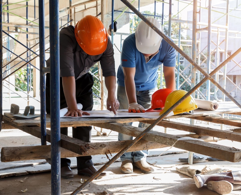 Construction workers on site looking at blueprint